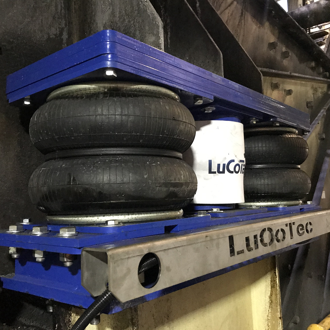 Molas pneumáticas pretas, fixadas em base metálica com pintura azul escuro.